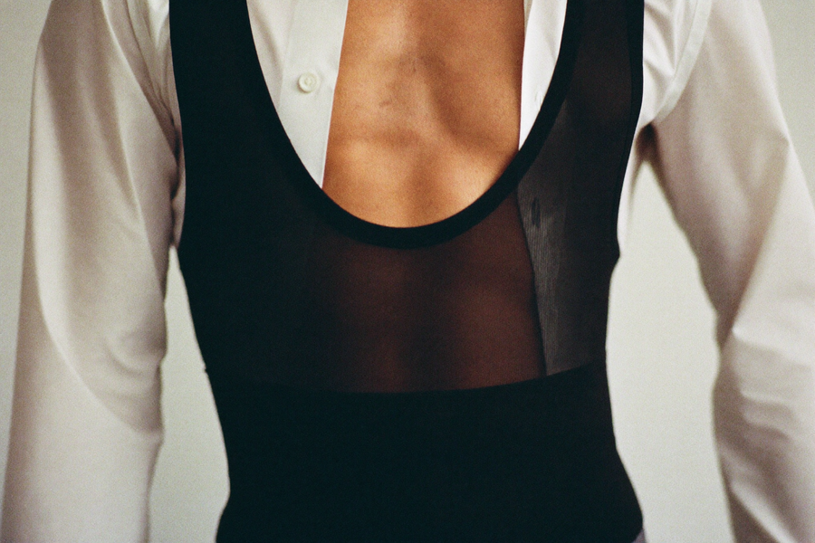 Man's torso in compression bodysuit under unbuttoned dress shirt, smooth midsection line