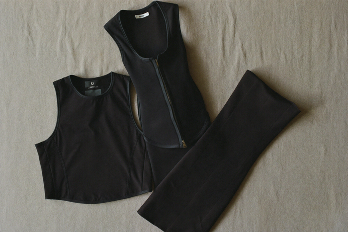 Three folded UNDR compression garments on bone surface, daily/support/full