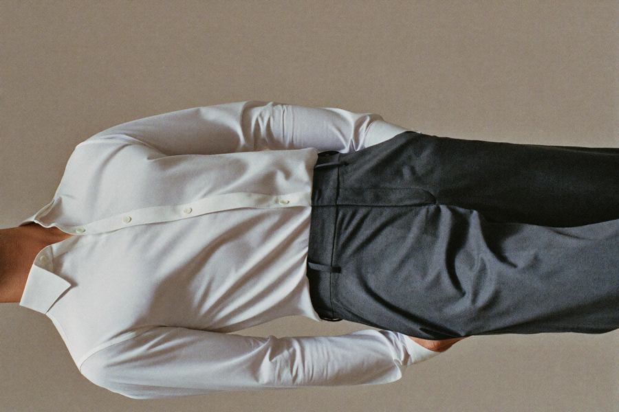 Man in fitted shirt with composed posture, clean midsection line