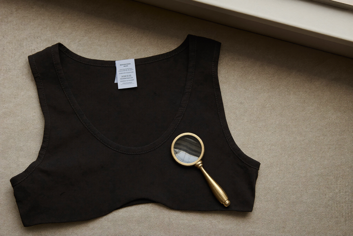 Magnifying glass over a compression vest tag, editorial still