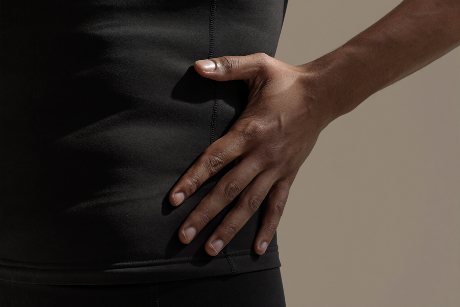 Man in fitted dress shirt with compression vest underneath, smooth chest line