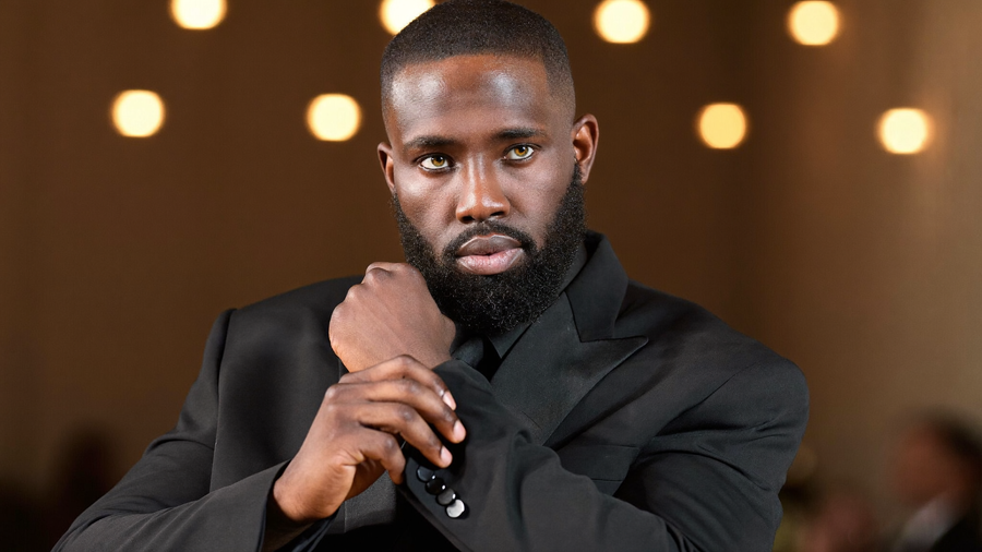 A man adjusting a tailored suit jacket at a formal event, representing UNDR's support for big days