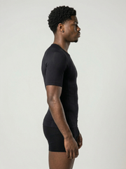 Person wearing a black t-shirt and shorts set against a plain background