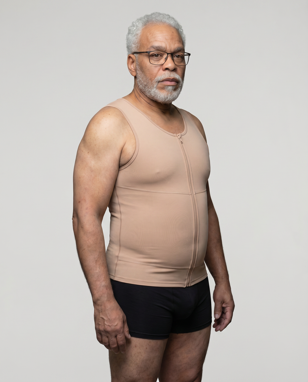 Man wearing a beige compression garment against a plain background