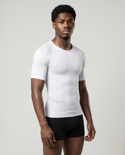 Man wearing a white compression shirt and black underwear on a light gray background