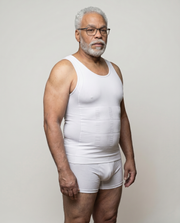 Man wearing a white tank top and underwear set against a plain background