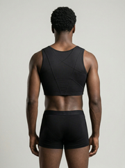 Person wearing a black sports bra and shorts set on a neutral background