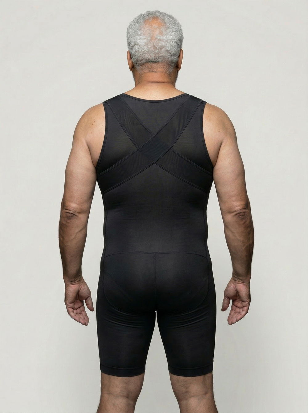 Person wearing a black sleeveless outfit on a plain background