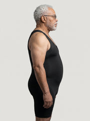 Man wearing a black compression garment against a plain background
