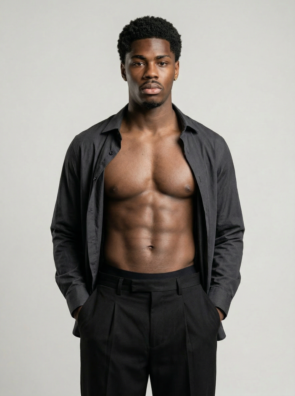 Man wearing a black shirt and pants against a plain background