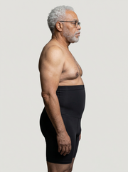 Man wearing black underwear against a plain background
