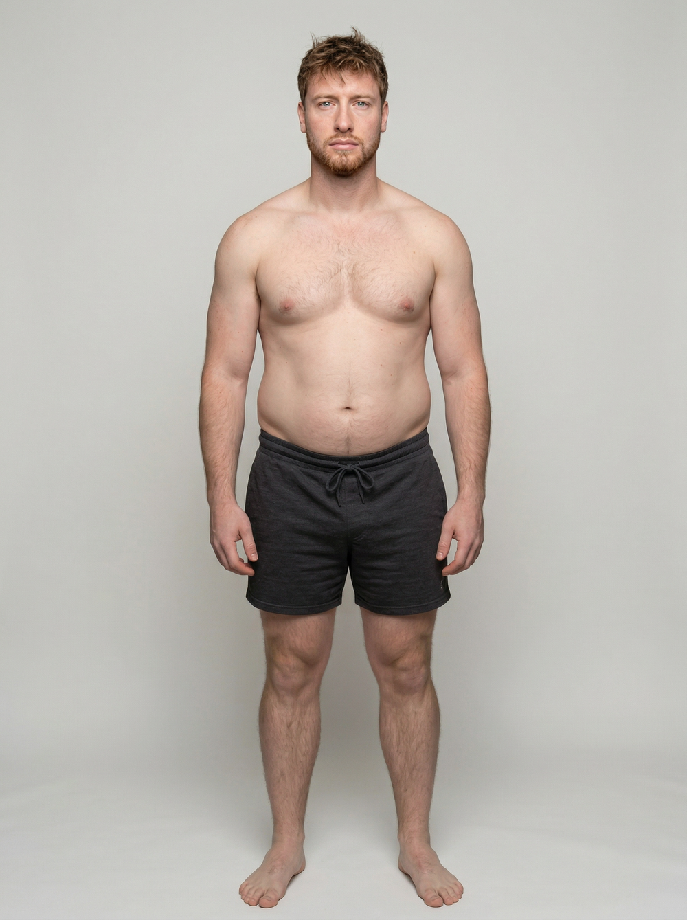 Man wearing black shorts against a plain background