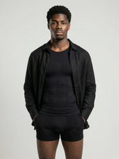 Man dressed in black, UNDR Posture Control T-Shirt as the base layer