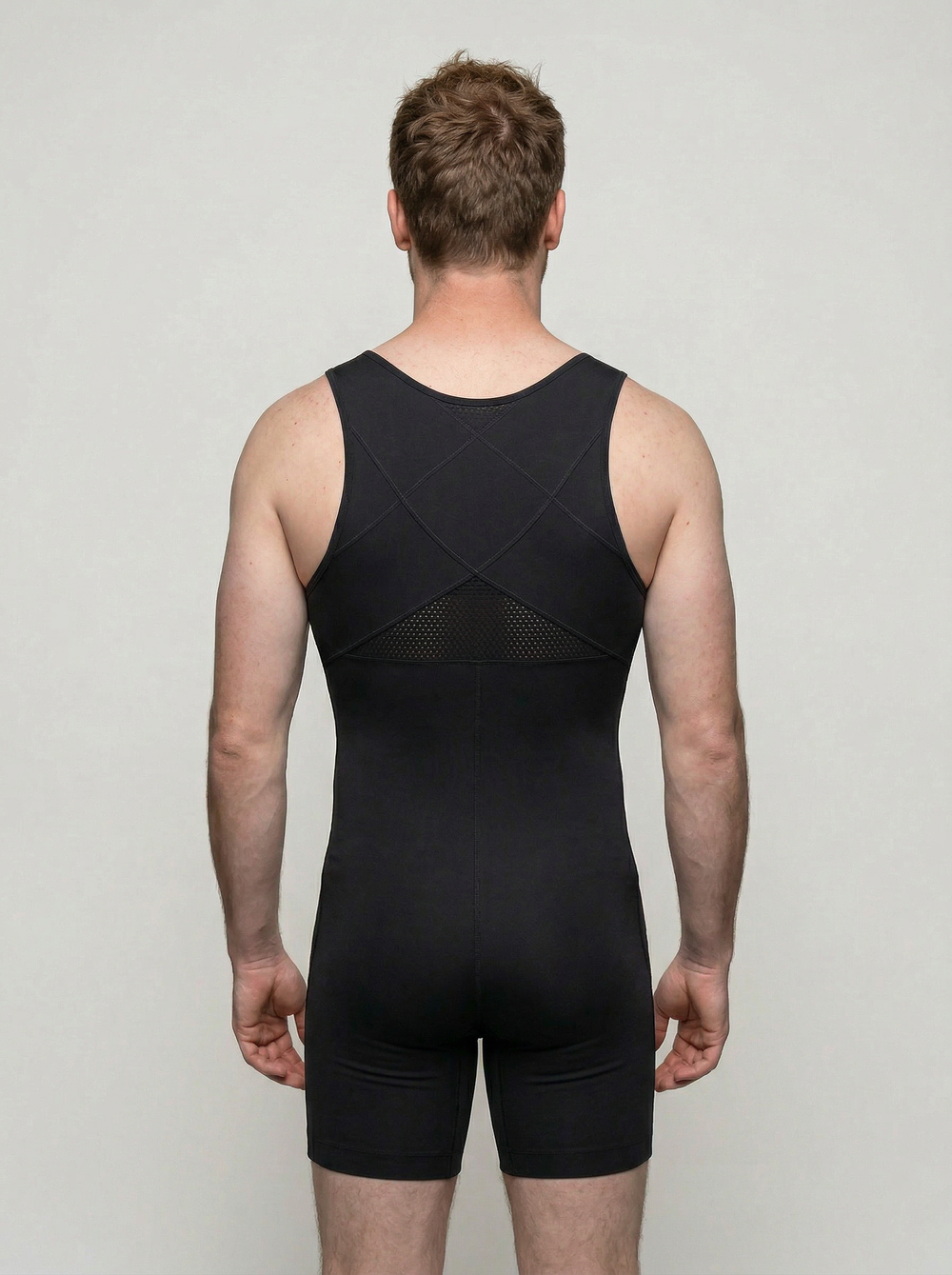 Person wearing a black unitard against a plain background
