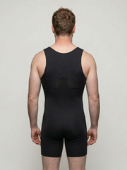 Person wearing a black unitard against a plain background
