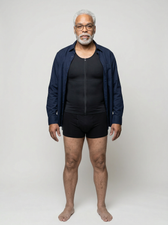 Man layering a navy jacket over the UNDR Zip Closure Compression Vest